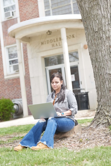 woman typing on laptop outside